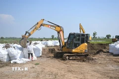 Công nhân lấp đầy bao cát để ngăn lũ tại một ngôi làng ở Khu tự trị Nội Mông, Trung Quốc. (Ảnh: THX/TTXVN)