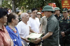 Phó Thủ tướng Trần Hồng Hà tặng quà các hộ bị ngập hoàn toàn. (Ảnh: Chu Hiệu/TTXVN)
