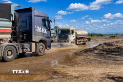 Đơn vị thi công tăng cường bố trí liên tục các xe chuyên dụng thay nhau tưới nước dọc các tuyến đường công vụ nhằm hạn chế tối đa tình trạng bụi bay vào khu dân cư. (Ảnh: TTXVN phát)