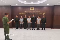 Công an thi hành Lệnh bắt tạm giam đối với 3 bị can. (Ảnh: TTXVN phát)