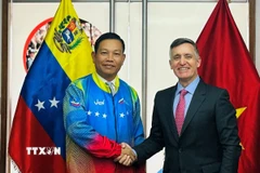 Đại sứ Vũ Trung Mỹ mặc áo đội tuyển Olympic quốc gia Venezuela do Bộ trưởng Franklin Cardillo trao tặng. (Ảnh: ĐSQ cung cấp)