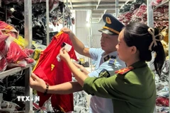 Một số lượng lớn quần áo mang nhãn hiệu NIKE, ADIDAS, PUMA bị lực lượng chức năng phát hiện. (Ảnh: TTXVN phát)