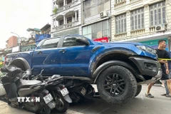 Ôtô tông liên hoàn nhiều xe máy tại phố Khâm Thiên. (Ảnh: Huy Hùng/TTXVN)