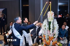 Tổng Bí thư Tô Lâm cùng Tổng Bí thư, Chủ tịch nước Lào Thongloun Sisoulith thực hiện nghi lễ buộc chỉ cổ tay truyền thống của Lào. (Ảnh: Dương Giang/TTXVN)