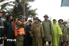 Phó Thủ tướng Trần Hồng Hà nghe báo cáo về tình hình xâm thực, xói lở bờ biển An Bàng. (Ảnh: Anh Dũng/TTXVN)