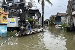 Mưa lớn gây ngập khiến người dân phải di chuyển bằng ghe. (Ảnh: Mai Trang/TTXVN)