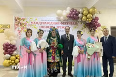 Nhóm nghệ thuật của cộng đồng người Việt Nam và Tổng lãnh sự Nguyễn Việt Kiên (đứng giữa) chụp ảnh lưu niệm. (Ảnh: TTXVN phát)