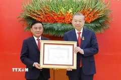 Đồng chí Trần Cẩm Tú, Ủy viên Bộ Chính trị, Thường trực Ban Bí thư trao Huy hiệu Đảng và chúc mừng Tổng Bí thư Tô Lâm. (Ảnh: Thống Nhất/TTXVN)