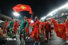 Các cầu thủ U22 Việt Nam hân hoan chia vui với người hâm mộ trên sân Rajamangala. (Ảnh: Minh Quyết/TTXVN)