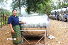 Người dân phấn khởi vì được hỗ trợ, tặng các thiết bị thu gom và bình lọc nước. (Ảnh: Võ Dung/TTXVN)