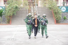 Bộ đội biên phòng áp giải các đối tượng vận chuyển ngoại tệ qua biên giới. (Ảnh: TTXVN phát)