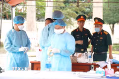 Đơn vị nghiệp vụ triển khai lấy mẫu hài cốt liệt sỹ đối với mộ chưa xác định được thông tin tại nghĩa trang liệt sỹ xã Đức Linh (Lâm Đồng). (Ảnh: Nguyễn Thanh/TTXVN)