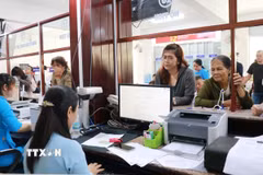 Người dân liên hệ bộ phận một cửa giải quyết các vấn đề liên quan hộ tịch. (Ảnh: Phan Sáu/TTXVN)