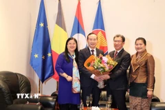 Đại sứ Nguyễn Văn Thảo và phu nhân tặng hoa chúc mừng Đại sứ Lào Kingphokeo Phommahaxay và phu nhân. (Ảnh: Hương Giang/TTXVN)