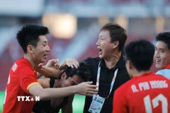 Thầy trò HLV Kim Sang Sik vỡ òa cảm xúc khi giành vé vào chung kết SEA Games 33. (Ảnh: Minh Quyết/TTXVN)