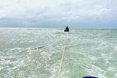 Lai dắt tàu cá gặp nạn vào bờ. (Ảnh minh họa: TTXVN phát)