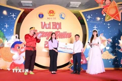 Bà Nguyễn Thị Hiền - Phó Giám đốc Quỹ Bảo trợ trẻ em Việt Nam trao biển tượng trưng tặng quà cho trẻ em có hoàn cảnh khó khăn tỉnh Tuyên Quang. (Ảnh: TTXVN phát)