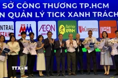 Đại diện Sở Công thương Thành phố Hồ Chí Minh thực hiện nghi thức trao quyền kiểm soát sản phẩm Tick xanh trách nhiệm cho 11 hệ thống phân phối. (Ảnh: Mỹ Phương/TTXVN)