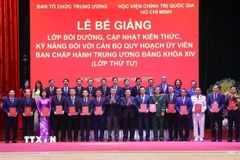 Trưởng Ban Tổ chức Trung ương Lê Minh Hưng và Giáo sư-Tiến sỹ Nguyễn Xuân Thắng, Giám đốc Học viện Chính trị quốc gia Hồ Chí Minh, Chủ tịch Hội đồng Lý luận Trung ương trao Giấy chứng nhận tốt nghiệp cho các học viên. (Ảnh: Văn Điệp/TTXVN)