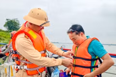 Việc hỗ trợ người dân mặc áo phao được lực lượng chức năng duy trì thường xuyên nhằm nâng cao ý thức bảo đảm an toàn giao thông đường thủy. (Ảnh: Trung Nguyên/TTXVN)