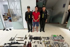 Nguyễn Huỳnh Vũ cùng tang vật là các loại vũ khí quân dụng. (Nguồn: Công an Thành phố Hồ Chí Minh)