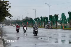 Người dân di chuyển dưới cơn mưa . (Ảnh: Hoàng Nhị/TTXVN)