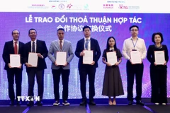 Đại diện doanh nghiệp Việt Nam và Trung Quốc trao đổi thoả thuận hợp tác tại diễn đàn. (Ảnh: Xuân Anh/TTXVN)