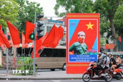 Cụm pano "Chủ tịch Hồ Chí Minh-Anh hùng giải phóng dân tộc Việt Nam, nhà văn hoá kiệt xuất" và cờ rực rỡ được bố trí trên phố Điện Biên Phủ. (Ảnh: Hoàng Hiếu/TTXVN)