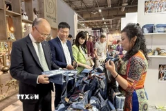 Đại sứ đặc mệnh toàn quyền Việt Nam tại Pháp Đinh Toàn Thắng tham quan gian hàng của doanh nghiệp Việt Nam. (Ảnh: Hữu Chiến/TTXVN)