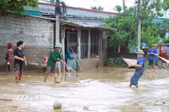 Người dân hỗ trợ nhau kéo bùn đất trên quốc lộ 7. (Ảnh: Xuân Tiến/TTXVN)