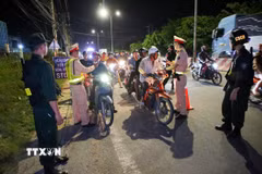 Lực lượng Phòng Cảnh sát Giao thông kiểm tra nồng độ cồn. (Ảnh: Giang Phương/TTXVN)