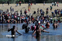 Người di cư vượt sông từ Ciudad Acuna, Mexico sang Mỹ. (Ảnh: THX/TTXVN)