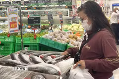 Người tiêu dùng lựa chọn mặt hàng thủy sản ở siêu thị. (Ảnh: Hương Giang/TTXVN)