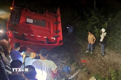 Phần đầu xe tải văng sang một bên đường ray, lật ngửa, biến dạng. (Ảnh: Lê Phước Ngọc/TTXVN)