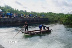 Lực lượng chức năng tìm nạn nhân. (Ảnh: TTXVN phát)