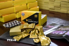 Lực lượng chức năng thu giữ tang vật vụ án. (Ảnh: TTXVN phát)