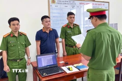 Cơ quan Cảnh sát điều tra tống đạt quyết định khởi tố bị can Huỳnh Đức Đạt. (Ảnh: Trọng Nguyễn/TTXVN phát)