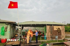 Đội Cảnh sát đường thủy số 2, Phòng Cảnh sát giao thông (Công an thành phố Hà Nội) đi từng xóm, đón từng thuyền, phát thẻ cử tri cho người dân trên sông Hồng. (Ảnh: TTXVN phát)