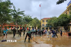 Các chiến sỹ Trung đoàn 6, Bộ Chỉ huy Quân sự thành phố Huế hỗ trợ nhân dân dọn dẹp vệ sinh sau mưa lũ. (Ảnh: Mai Trang/TTXVN)