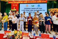 Trao tiền, quà hỗ trợ người dân vùng lũ. (Ảnh: CTV/TTXVN)