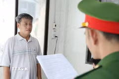 Cơ quan Công an tống đạt các quyết định và lệnh đối với bị can Nguyễn Huy Đạt. (Ảnh: TTXVN phát)