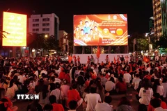 Người hâm mộ ngồi trật tự chuẩn bị xem trận bán kết qua màn hình Led khổng lồ có kích thước 12m x 7m tại phố đi bộ Nguyễn Huệ. (Ảnh: Trung Tuyến/TTXVN)