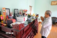 Thân nhân nhà báo, liệt sỹ Nguyễn Hữu Bản (sinh năm 1921 tại thôn Đại Lai, xã Phú Xuân, thị xã Thái Bình nay là phường Trần Hưng Đạo, tỉnh Hưng Yên) dâng hương trước ban thờ ông. (Ảnh: Thế Duyệt/TTXVN)
