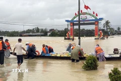Sử dụng ghe để tiếp tế lương thực cho người dân vùng lũ. (Ảnh: Tường Quân/TTXVN)