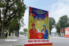 Những cụm pano cổ động được thiết kế bắt mắt, kết hợp hài hòa giữa màu sắc và thông điệp tuyên truyền về ngày hội ý nghĩa của non sông. (Ảnh: Huy Khánh/Vietnam+)