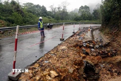 Lực lượng bảo dưỡng thường xuyên trực gác đảm bảo an toàn giao thông tại Km159+150 đường Hồ Chí Minh nhánh Tây bị sạt lở taluy âm, xói lở lề đường. (Ảnh: Tá Chuyên/TTXVN)