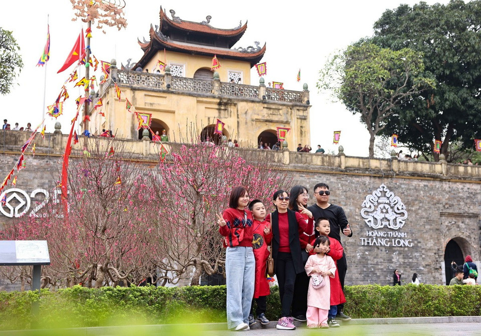 Một gia đình cùng vui vẻ tạo dáng bên kiến trúc cổ kính của Hoàng thành. (Ảnh: Thanh Tùng/TTXVN)