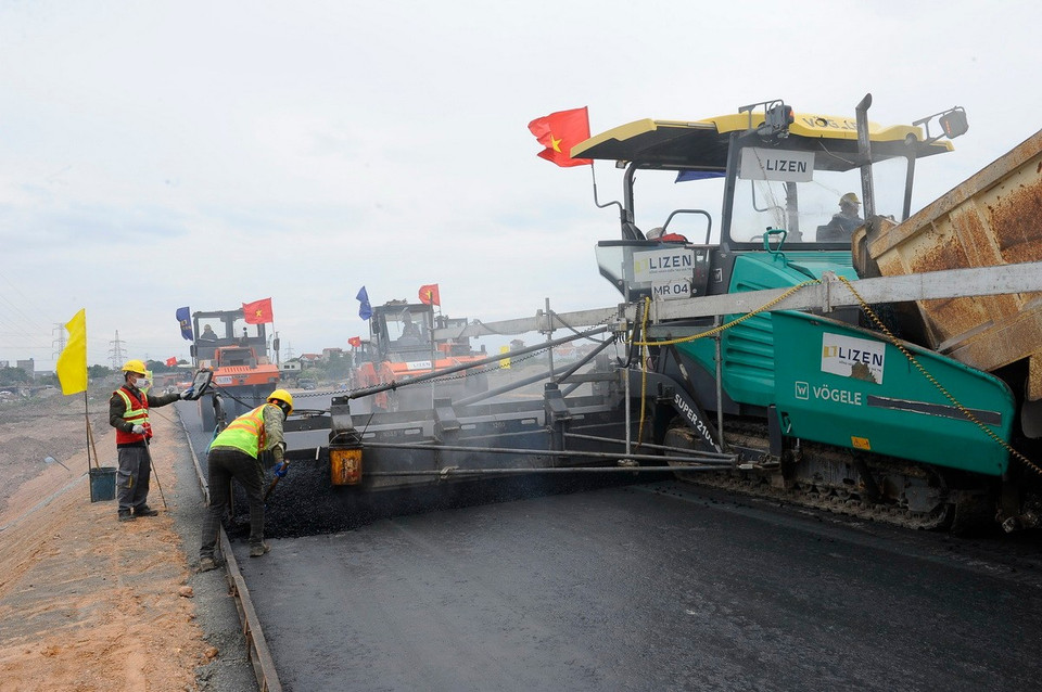 Thi công thảm bê tông nhựa tuyến đường song hành thuộc Dự án đường Vành đai 4 - Vùng Thủ đô Hà Nội qua địa bàn huyện Văn Giang (Hưng Yên). (Ảnh: Mạnh Khánh/TTXVN)