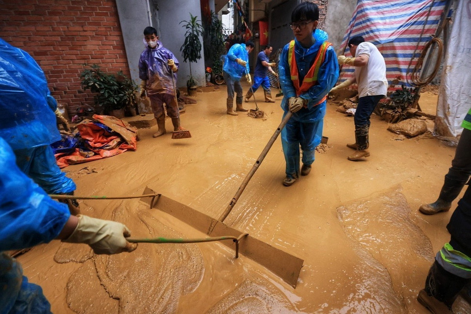 Công nhân vét bùn nhão, tập trung vào khu vực để xe hút bùn đến hút. (Ảnh: Tuấn Anh/TTXVN)