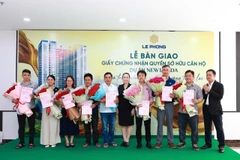 Đại diện Tập đoàn Lê Phong trao giấy chứng nhận quyền sở hữu căn hộ và hoa cho cư dân.